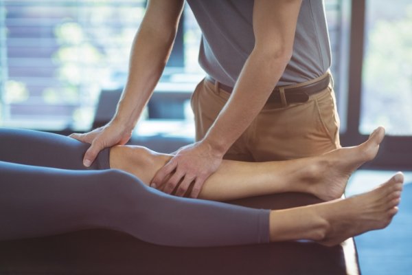 Physiotherapist massaging knee