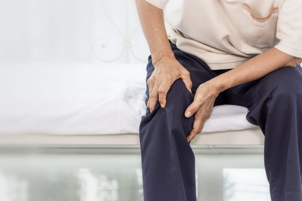 Person holding knee due to pain