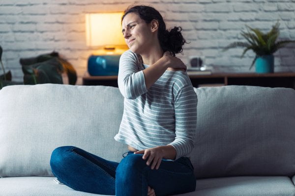 Woman sitting on a sofa with back pain